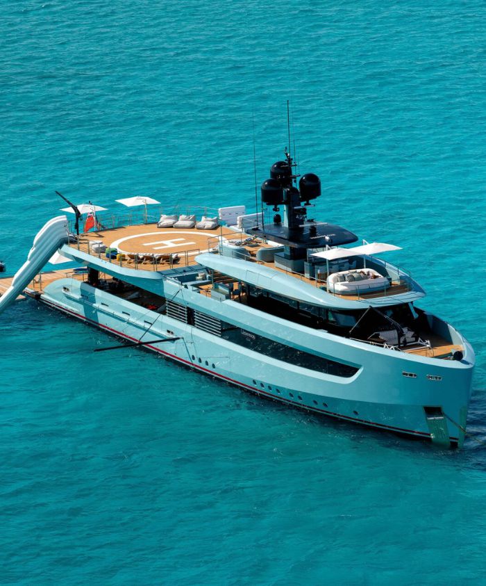 Blue luxury boat with heli pad in clear blue waters