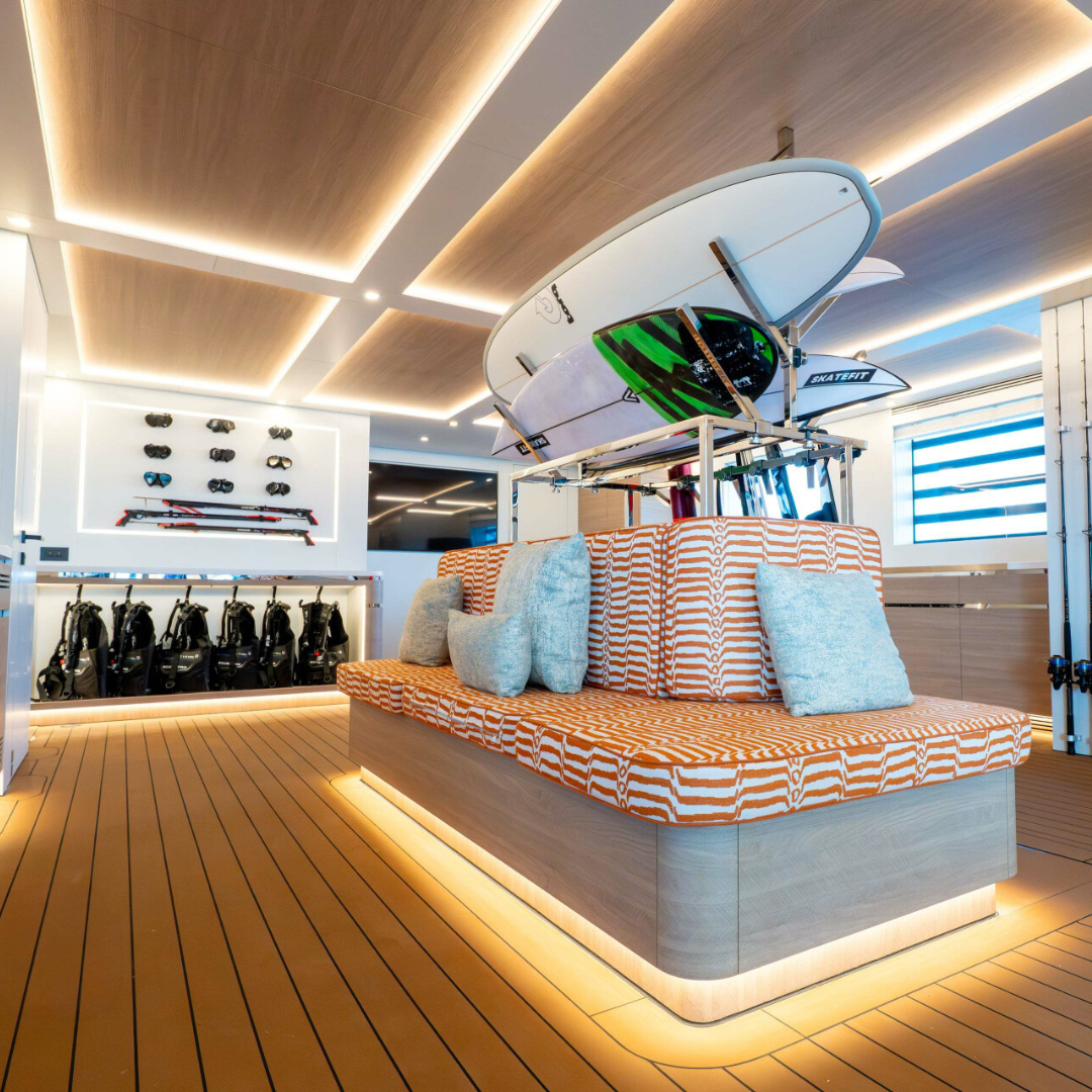 Interior of boat with bright lights, scuba equipment and surf boards