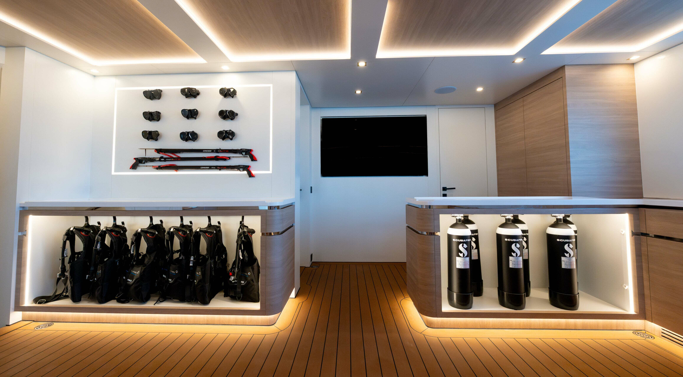 A lightly lit dive centre onboard a luxury boat. With scuba diving tanks, vests and masks.
