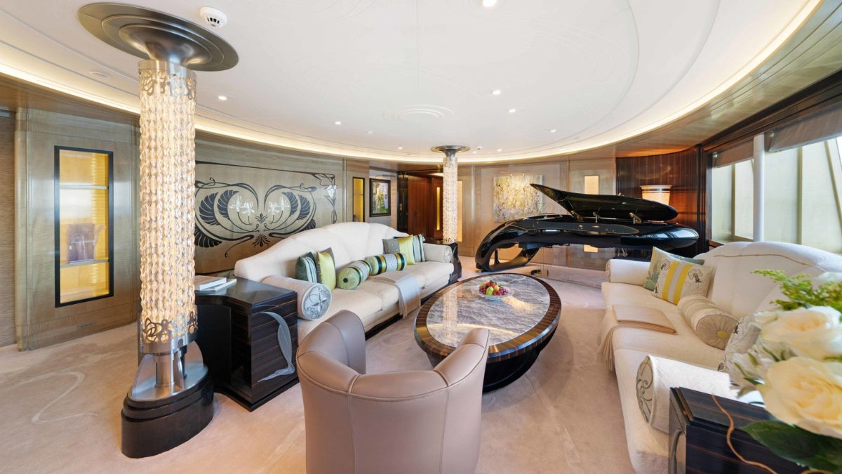 Luxurious yacht interior featuring a sleek grand piano, elegant seating with vibrant cushions, and artistic wall designs. Soft lighting enhances the sophisticated ambiance, creating a chic and inviting space.