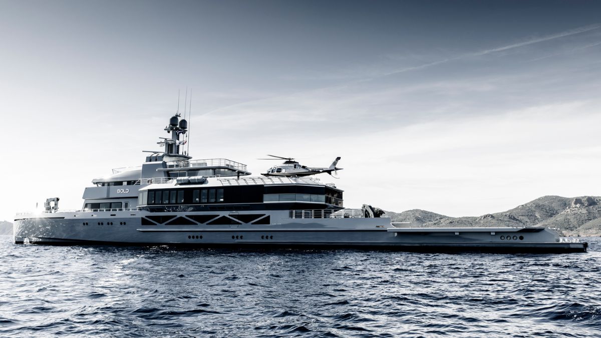 A large luxury yacht with a helicopter on the upper deck, anchored in calm waters against a backdrop of mountains. The image is rendered in a monochromatic palette, giving it a sleek, modern appearance.