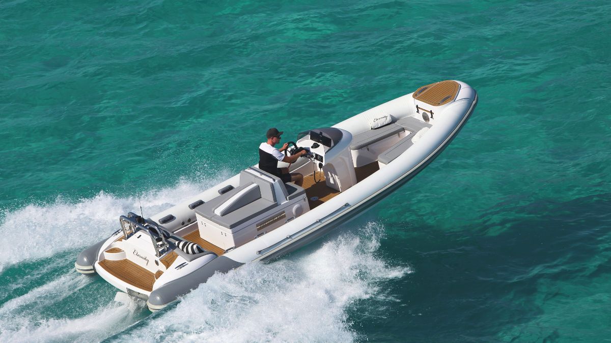 A speedboat glides over turquoise waters, with a man at the helm navigating through the waves.