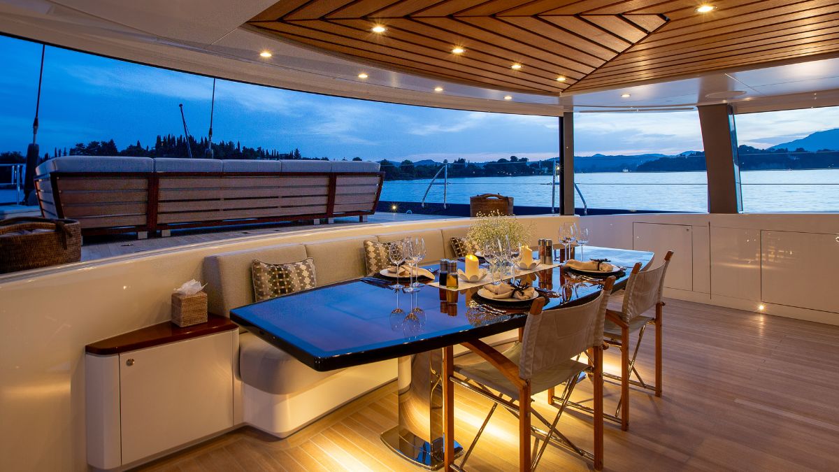 Aftdeck of large luxury sailing yacht with sofas and outdoor al fresco dining table