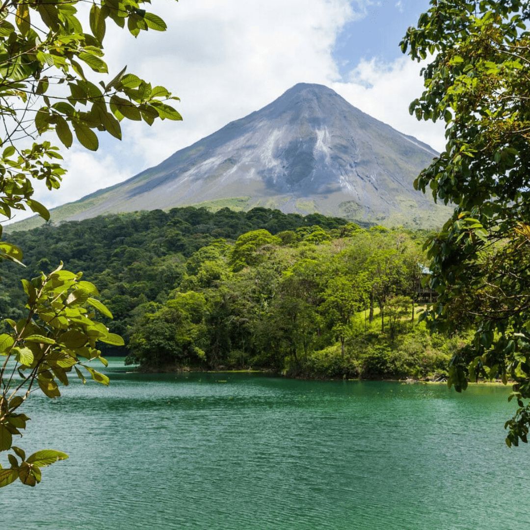Volcano in Costa Rica with trees and river in foreground