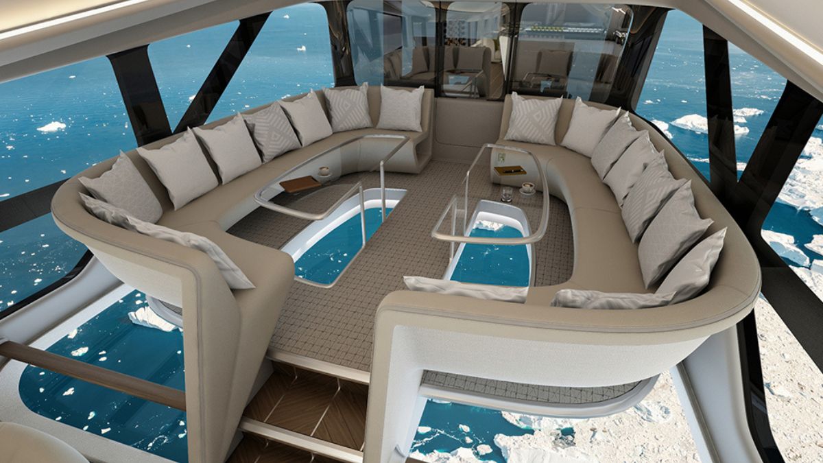 A luxurious lounge area with a curved sectional sofa, offering a stunning view of icy waters through large floor-to-ceiling windows. The space is elegantly designed with plush cushions, a coffee table, and a serene ambiance.