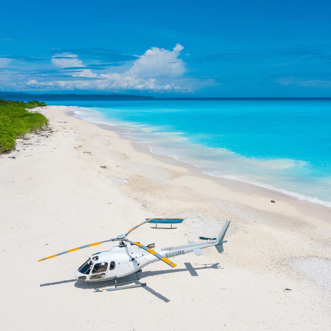 Helicopter on a private beach in papua new guinea as part of the luxury travel concierge service at Pelorus