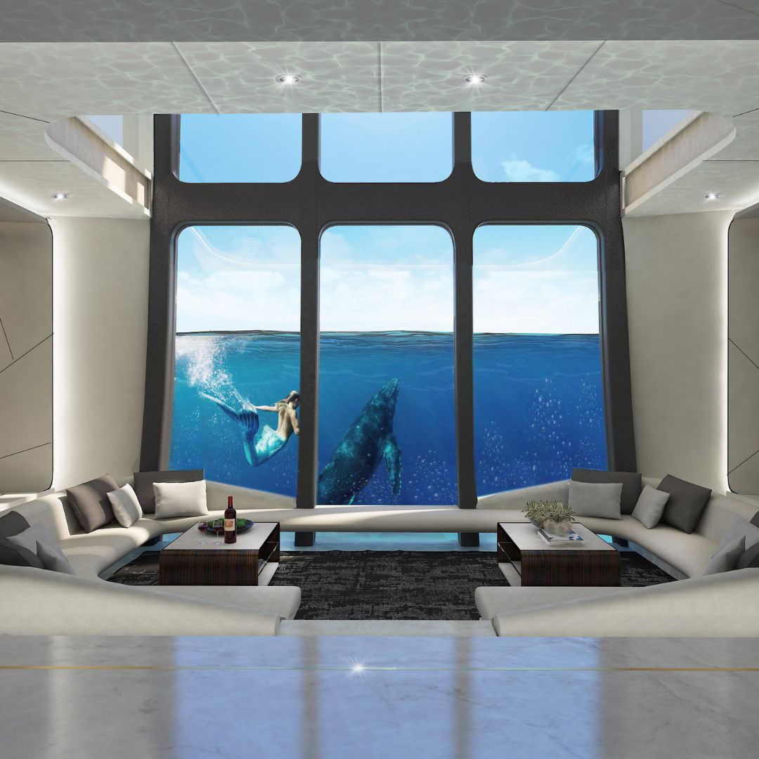 A spacious modern living room features large windows overlooking a serene ocean scene with a woman swimming alongside a whale. The interior is sleek, with minimalist furniture and soft furnishings.
