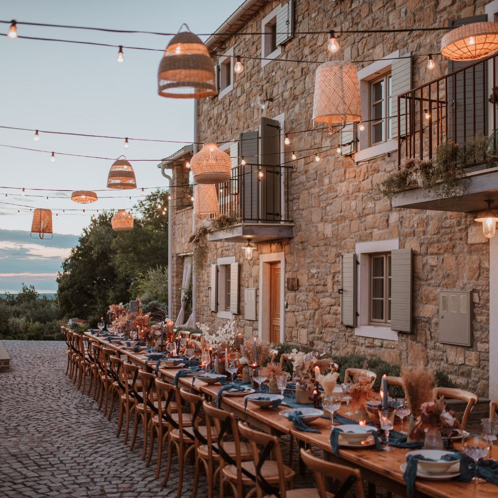 dinner party set up outside under fairy lights