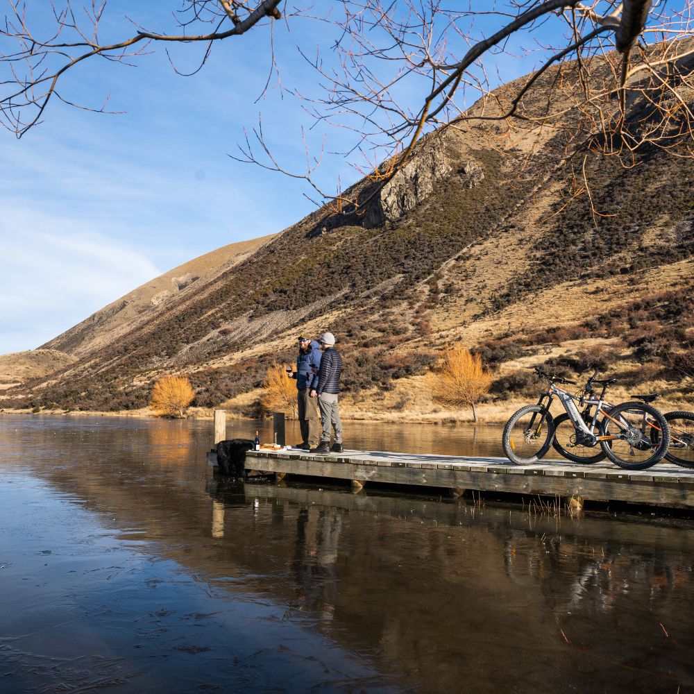 two people standing by the lake