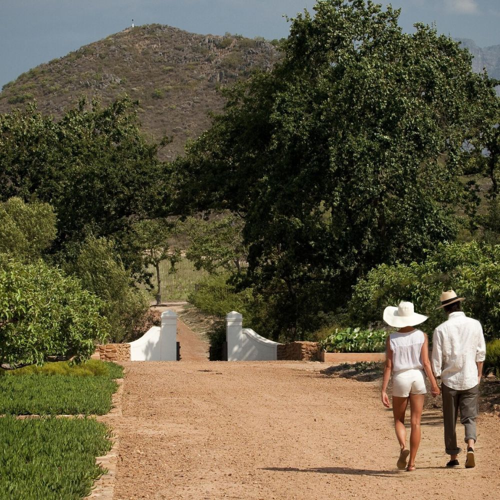A couple walking towards a gate on Babylonstoren grounds