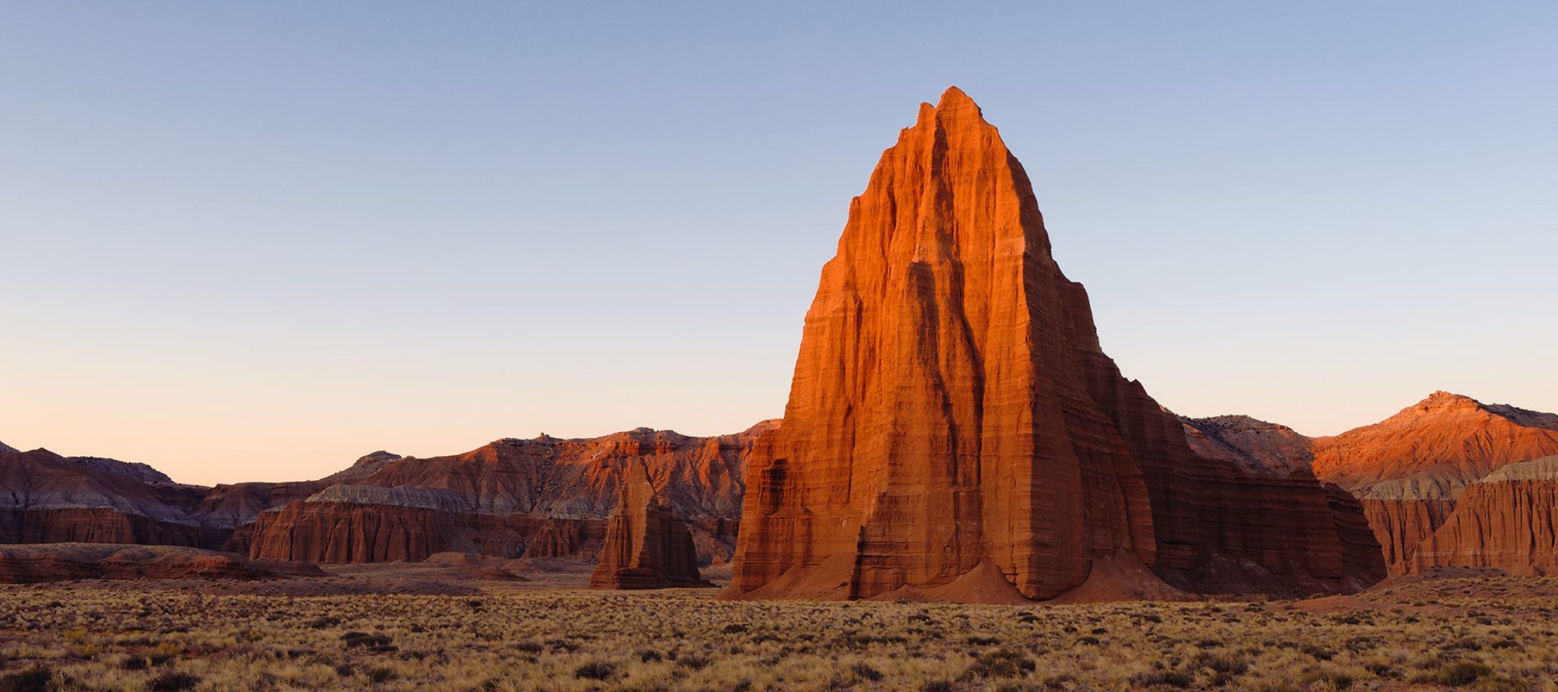 Sunlit red rock formations in Utah, a dramatic stop on a Utah national parks road trip adventure.