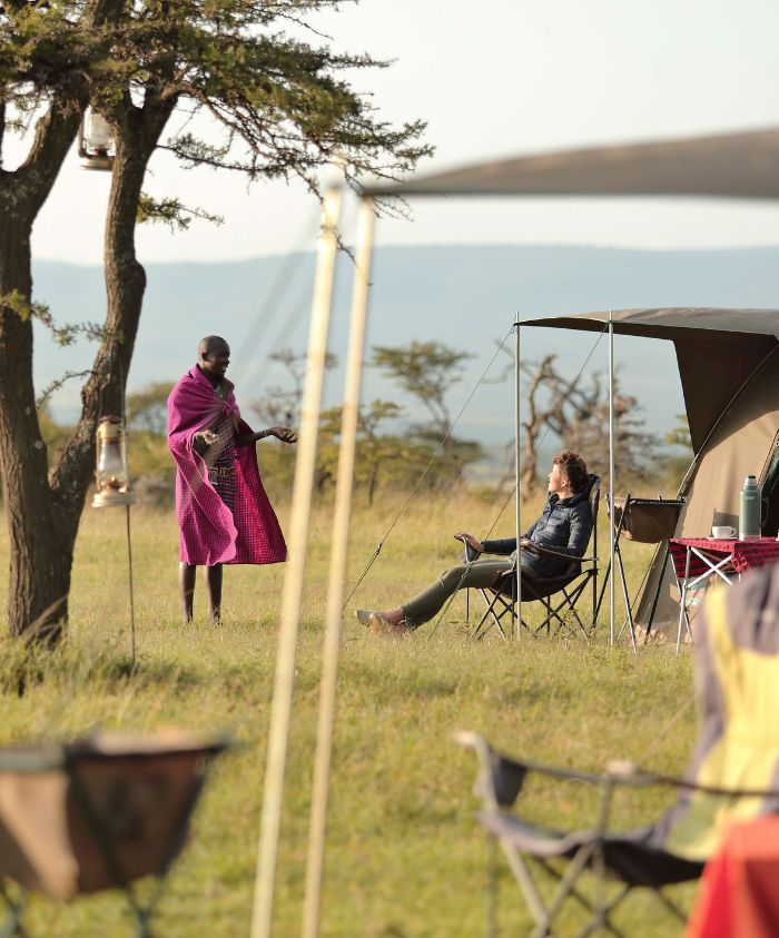 guest talking to a tribe member in a remote camp