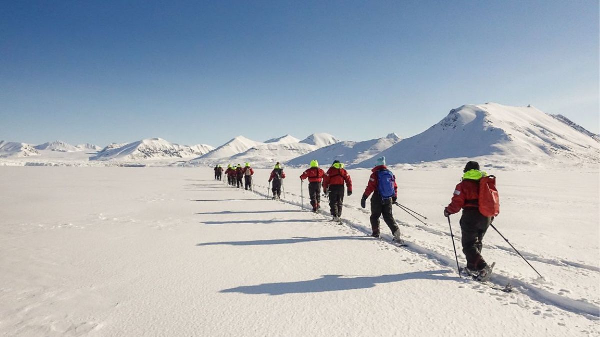 A group of Pelorus clients snowshoeing in Svalbard in June on their alternative luxury summer vacation.
