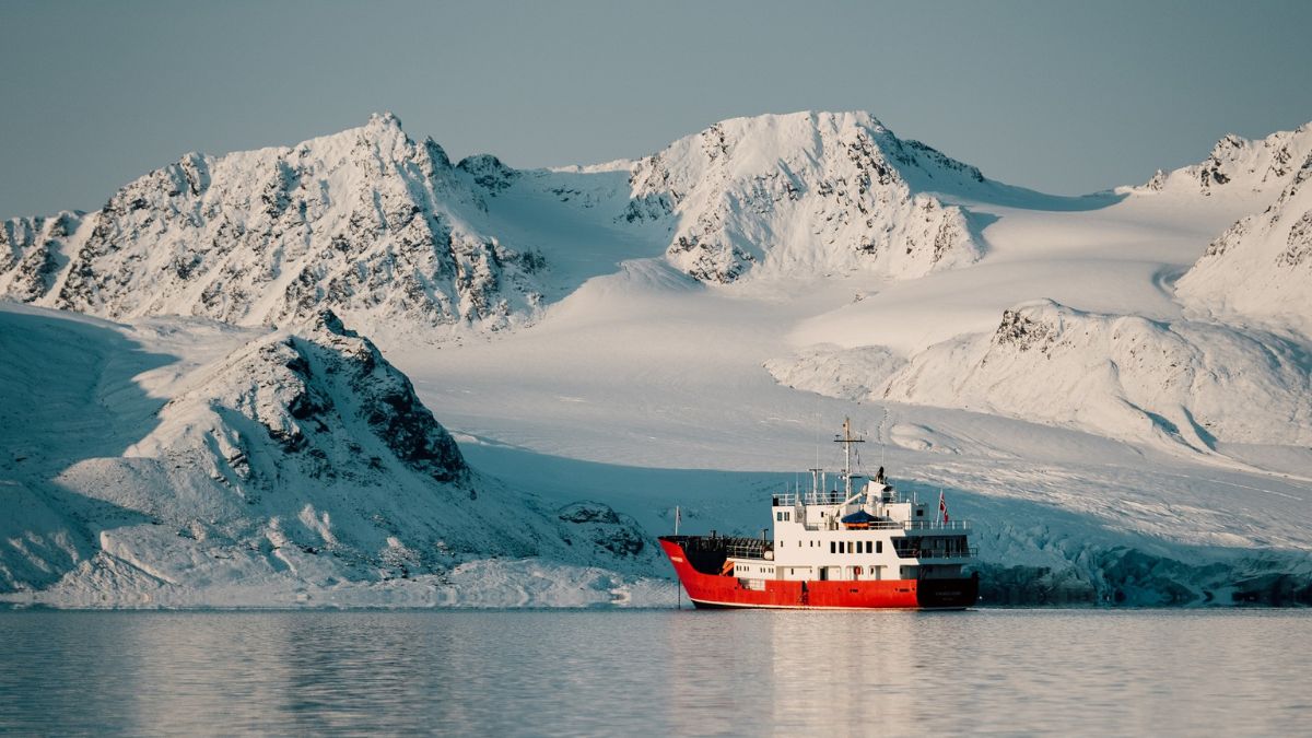 Luxury explorer yacht in icy seas surrounded by hills – Pelorus Yachting 2026 cinematic Odysseus voyage, Arctic eclipse, and Galápagos conservation.