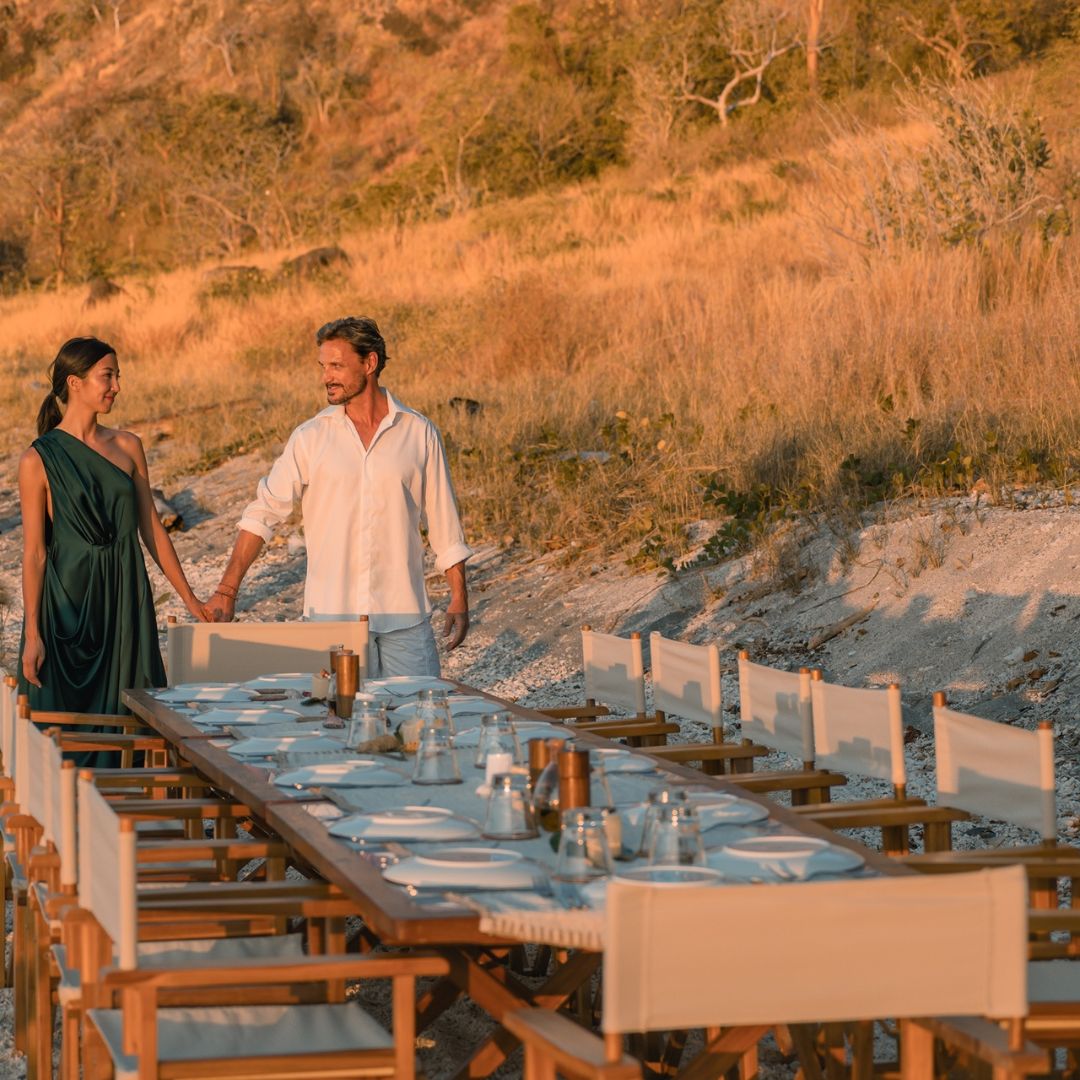 Outdoor wedding dinner on a private beach at sunset, luxury yacht wedding charter
