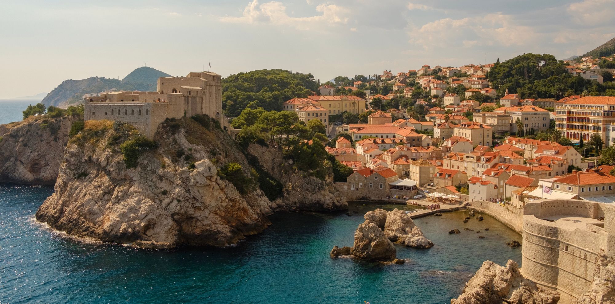 Rocky coastline with castle and houses on hill